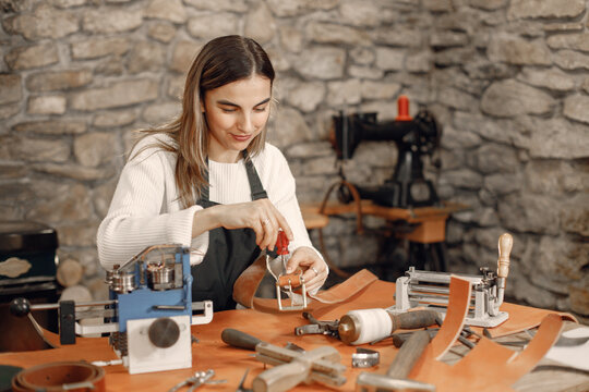 Female leather craftsman working on a belt