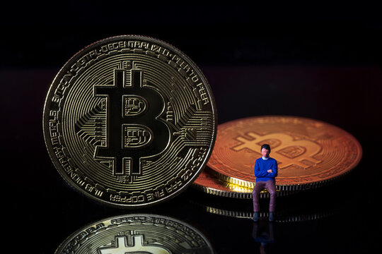 Miniature people : Man sitting on Bitcoin digital money crypto currency concept. Macro