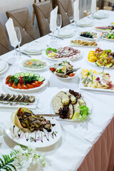 Serving a festive table in a restaurant. Preparation of a banquet for a holiday. Expensive decoration materials. Dishes for food and drinks