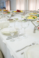 Serving a festive table in a restaurant. Preparation of a banquet for a holiday. Expensive decoration materials. Dishes for food and drinks