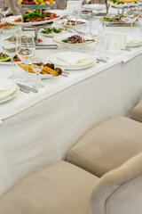 Serving a festive table in a restaurant. Preparation of a banquet for a holiday. Expensive decoration materials. Dishes for food and drinks
