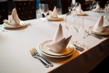 Serving a festive table in a restaurant. Preparation of a banquet for a holiday. Expensive decoration materials. Dishes for food and drinks