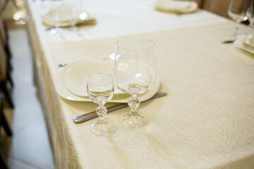 Serving a festive table in a restaurant. Preparation of a banquet for a holiday. Expensive decoration materials. Dishes for food and drinks