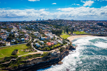 Aerial drone view of iconic Bronte Beach and nearby coastline in Sydney, Australia during summer on a sunny day  