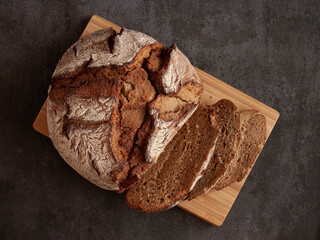 Sliced rye bread on a cutting wooden board. Whole-grain rye bread
