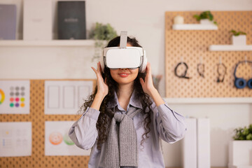 Asian woman wearing virtual reality goggles in modern coworking studio. Smartphone using with VR headset.