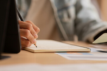 Close up hand Asian man use pen write and note job in paper on desk,work from home.
