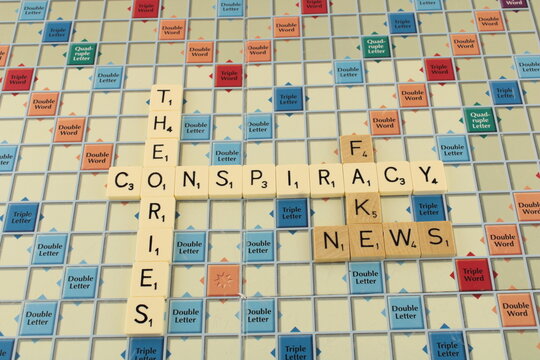 Conspiracy theories and fake news on a scrabble board background. Propaganda concept