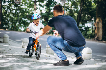 Fototapeta premium Father teaching his little son to ride a bicycle