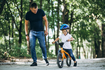 Obraz premium Father teaching his little son to ride a bicycle