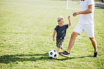 Father with son playing football at the field