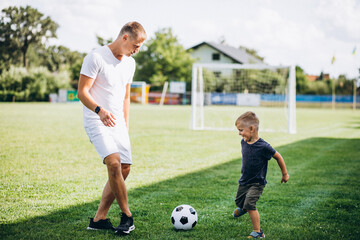 Father with son playing football at the field