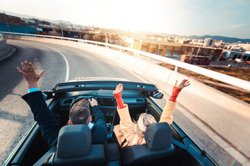 Happy couple driving on the road in convertible car - Friends rent cabrio auto on vacation -...