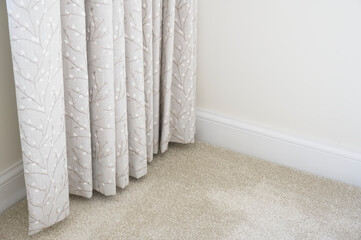 Neutral colour home interior showing curtains and carpet