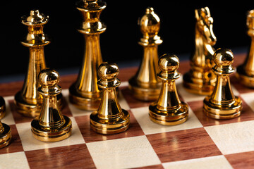 Golden chess figures standing on chessboard