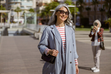 Fototapeta premium Well dressed female taking stroll through city