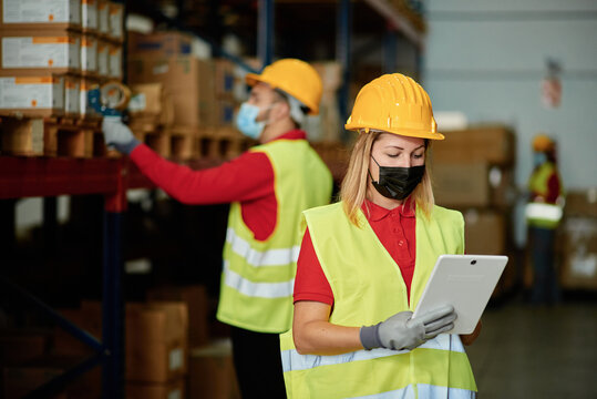 Workers in protective masks using tablet