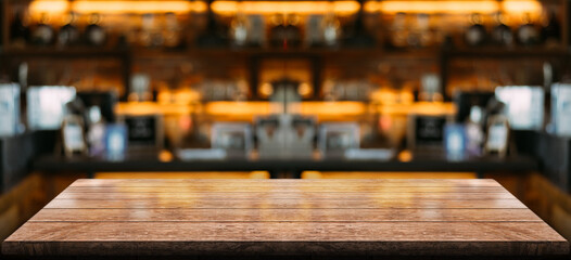 Empty wooden table top with lights bokeh on blur restaurant background.