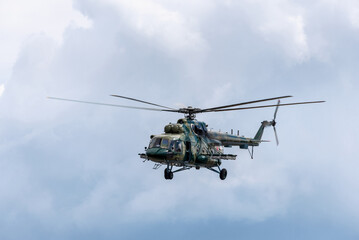 Russian military helicopter Mil Mi-8 in flight against a cloudy sky