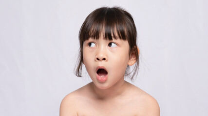 beautiful young Asian girl looks shocked at things. The girl gave a surprised expression and looked to the side. Expressive facial emotions