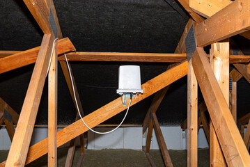 Antenna amplifier for mobile internet at home, mounted on roof trusses in the attic.