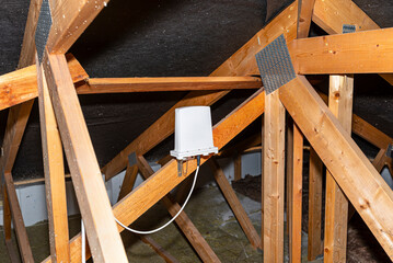 Antenna amplifier for mobile internet at home, mounted on roof trusses in the attic.