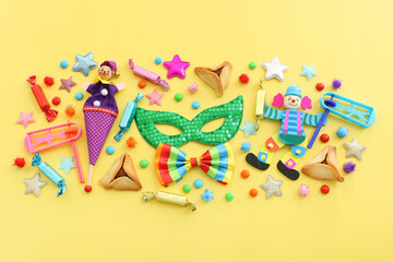 Purim celebration concept (jewish carnival holiday) over yellow background. Top view, flat lay