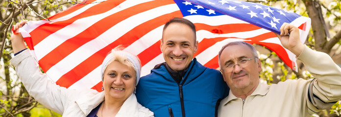 Family at front door on fourth of July with flags and cookies smiling