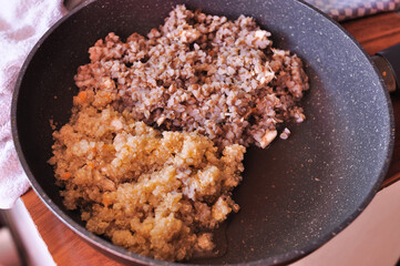Boiled buckwheat and quinoa on frying pan 