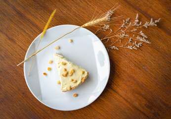 Coconut Cream Pie in the white dish on the wood table that topping with macademia. Shooting in the...