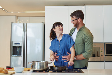 Dinner is almost ready. Shot of a mature couple cooking together at home.