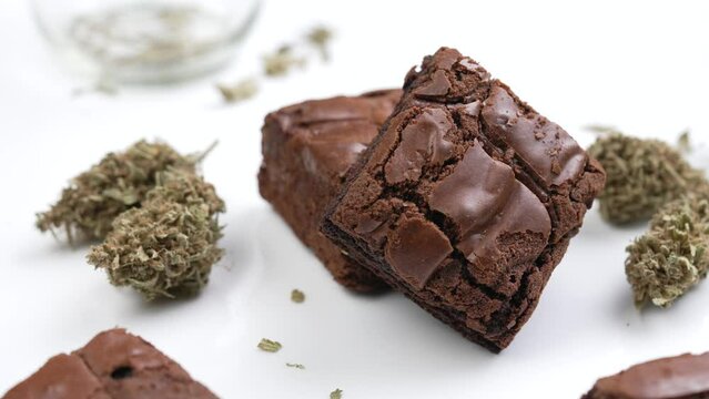 Cannabis brownies and cannabis flowers on white table for home consumption and recreational medicinal purposes isolated on white background