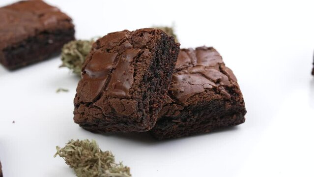 Cannabis brownies and cannabis flowers on white table for home consumption and recreational medicinal purposes isolated on white background