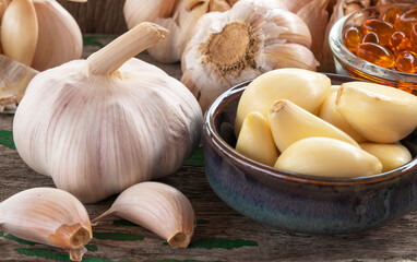 Garlic bulb on green wooden background.
