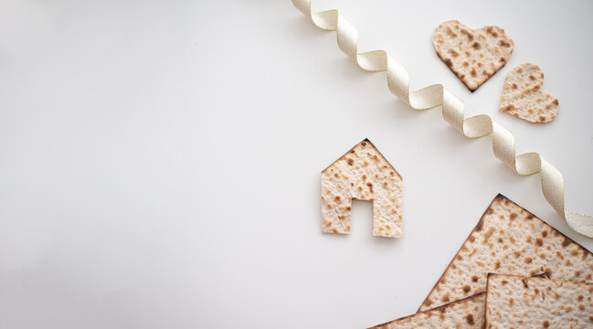 Layout of Matzah shape of small house, hearts and tape on white background. Traditional of Jewish Holiday on Passover. Home symbol of happy family. Purchase or rent. top view. Real Estate Agency