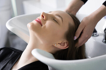 Hairdresser washing a client's head in a salon