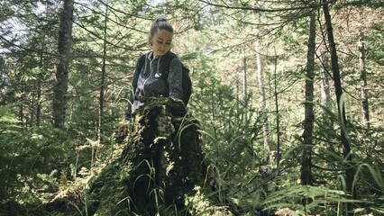 Fototapeta premium Traveler photographing scenic view in forest. One caucasian woman shooting nice magic look. Girl take photo video on dslr mirrorless camera. Professional photographer travel with backpack. Outdoor.