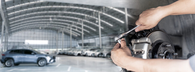Car service concept photo, Hand a man holding a wrench repairing car brakes and car service center...