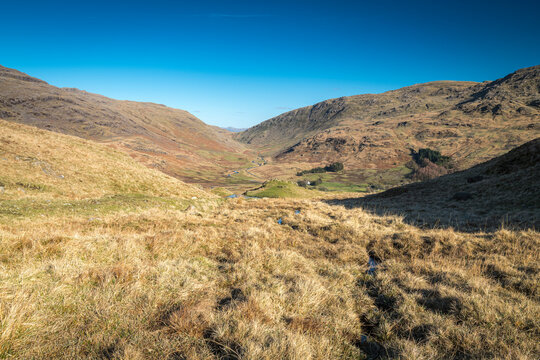 A sunny, winter HDR landscape image of wrynose bottom from the top of Hardknott Pass with a distant Helvellyn, Cumbria, England