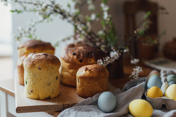 Homemade easter breads, natural dyed eggs and spring blossom on rustic table in room. Happy Easter! Freshly baked easter cakes, traditional ukrainian bun