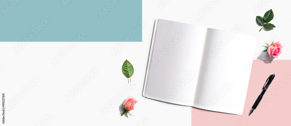 Poster open notebook or diary with a pen from above with rose buds- flat lay