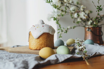 Happy Easter!  Homemade easter bread, natural dyed eggs and spring blossom on rustic table in room....