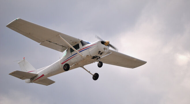 Avioneta a voar no c&eacute;u enublado, fotografado de baixo para cima