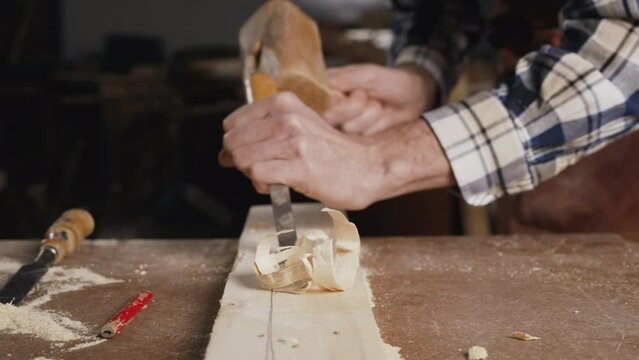 Close up of a Carpenter carving wood with chisel . High quality 4k footage