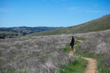 Fototapeta premium A Beautiful Woman Hiking a Trail in Springtime California Hills