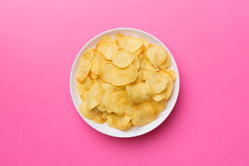 Potato chips on bowl isolated on colored background. Delicious crispy potato chips in bowl. Space for text. Top view