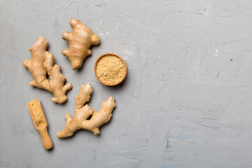 Finely dry Ginger powder in bowl with green leaves isolated on colored background. top view flat lay
