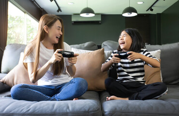 girl with mother using joystick playing video game