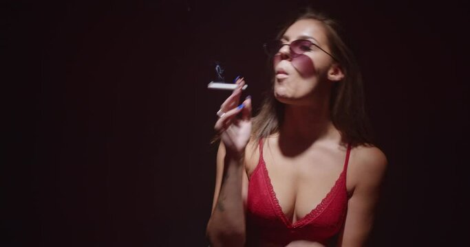 Cool girl with sunglasses smoking and throwing her hair