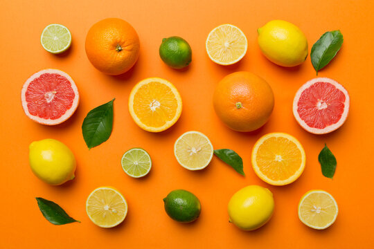 Flat lay of citrus fruits like lime, orange and lemon with lemon tree leaves on light colored background. Space for text healthy concept. Top view